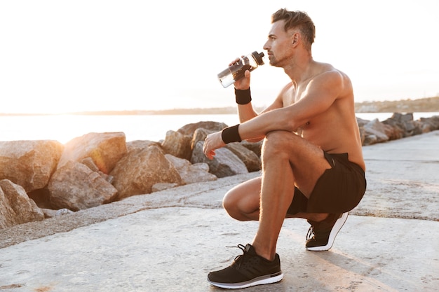 Portrait of a strong shirtless sportsman resting after jogging