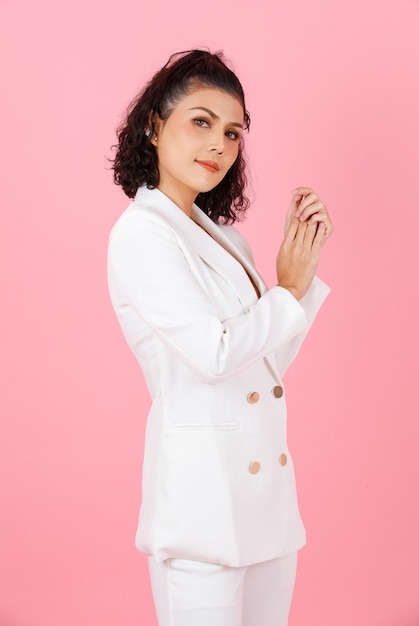 Portrait studio shot of Asian sexy curly hairstyle professional successful businesswoman in white fashionable casual suit with lace lingerie crop top bra standing look at camera on pink background