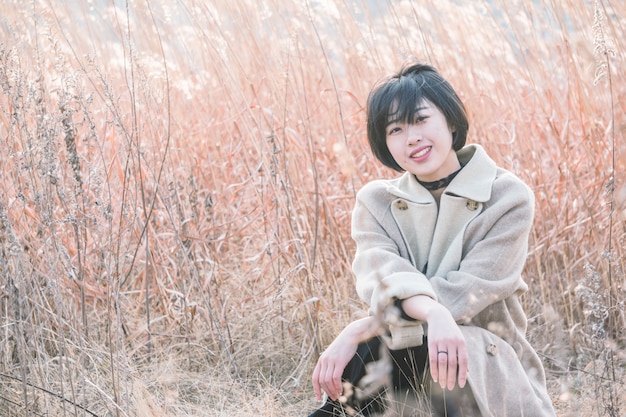 portrait of style woman sitting amidst reed field