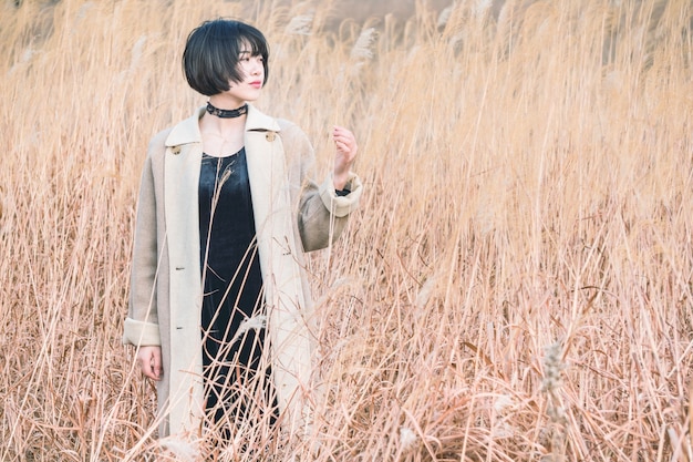 portrait of style woman standing amidst reed field