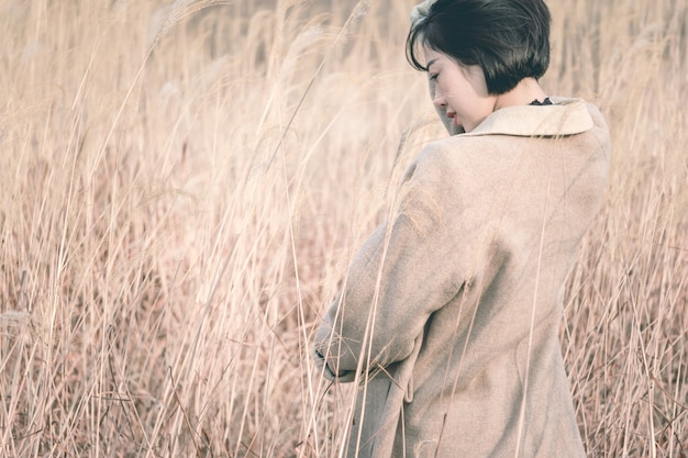 portrait of style woman standing amidst reed field