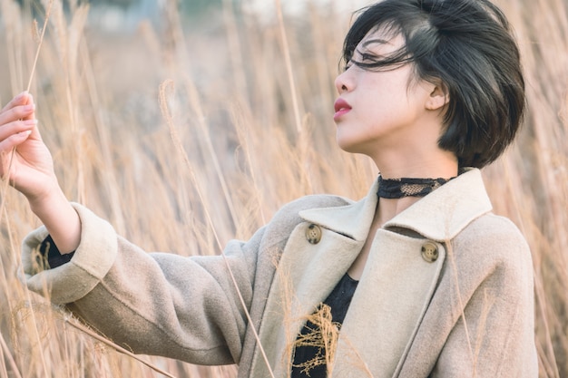 portrait of style woman standing amidst reed field