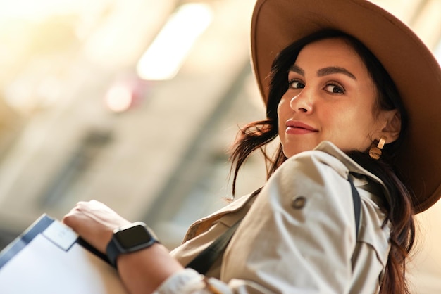 Portrait of a stylish beautiful caucasian woman wearing hat looking at camera while walking city