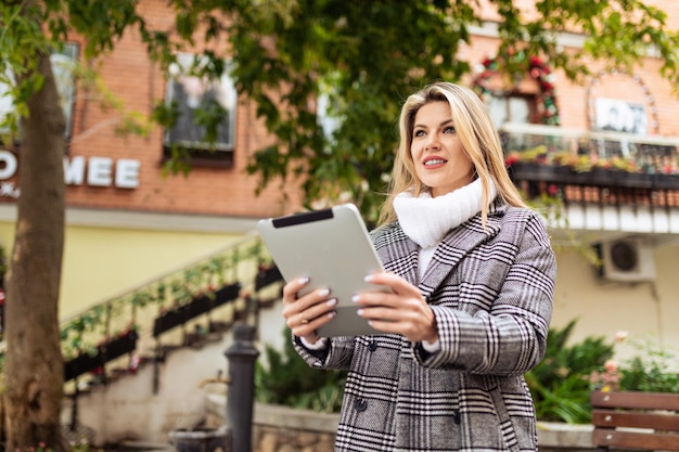 Portrait of a stylish business woman with a tablet in her hands on the background of the urban