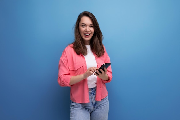 Portrait of stylish dark haired young woman with hollywood smile isolated with studio background