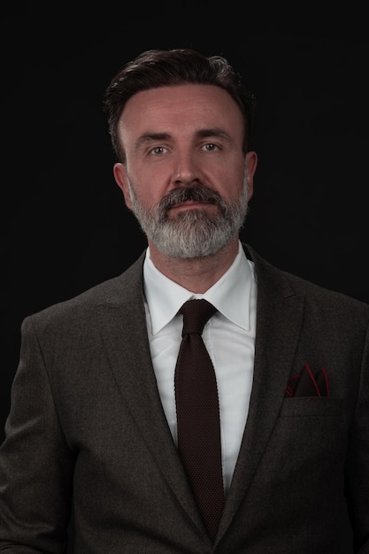 Portrait of a stylish elegant senior businessman with a beard and casual business clothes in photo s