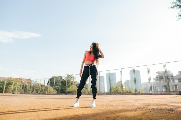 Portrait of a stylish girl on the old tennis field