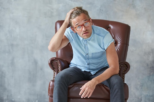 Portrait of a stylish intelligent man stares into the camera small unshaven charismatic blue shirt s