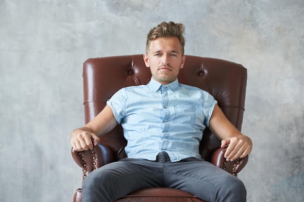 Portrait of a stylish intelligent man stares into the camera small unshaven charismatic blue shirt s