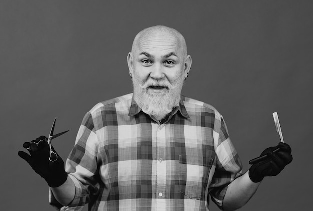 Portrait of stylish man bearded man with grey moustache beard old barber with scissors and razor vin