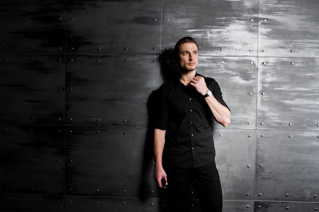 Photo portrait of stylish man wear on black shirt against steel wall.