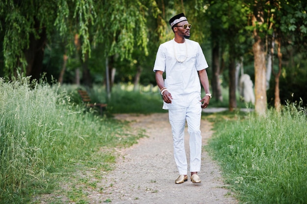 Portrait of stylish and rich black african american man on white clothes sunglasses and hat