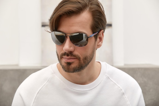 Portrait of a stylish successful young man in sunglasses young brunette businessman in sun glasses stylish portrait of a young man