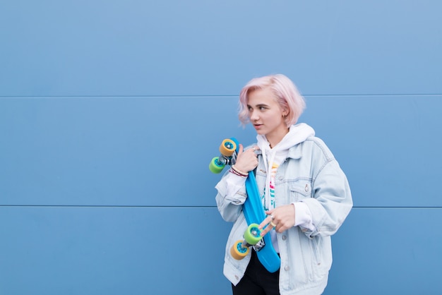 Portrait of a stylish teen girl with skateboard