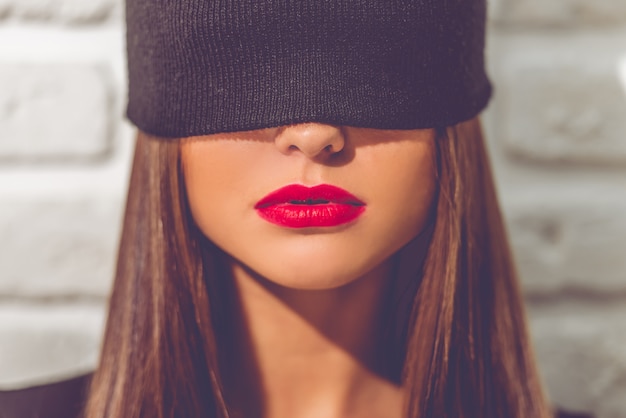 Photo portrait of stylish young girl with a black cap on her eyes.