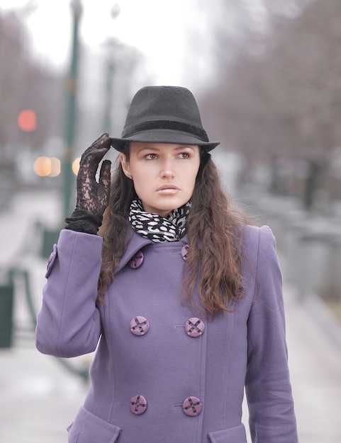 Portrait of stylish young woman on city background.