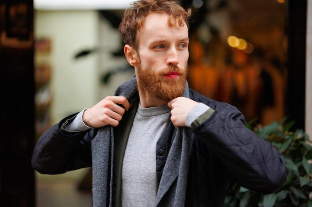 Portrait of a stylishly dressed bearded man posing outdoor