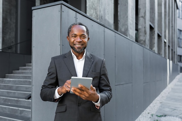 Portrait of a successful african american boss a businessman in a suit smiling and looking at the