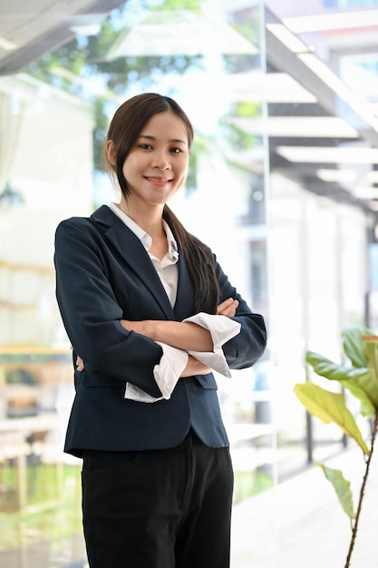 Portrait of a successful Asian businesswoman stands with arms crossed in the office