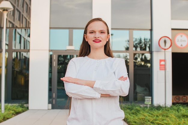 Portrait of a successful business woman using digital tablet in front of modern business building