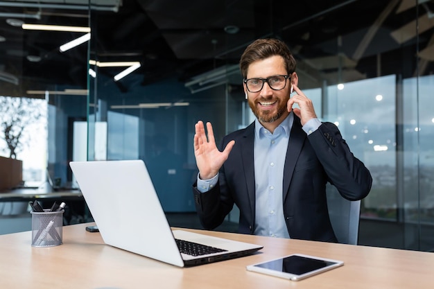 Portrait of a successful businessman inside a modern office a man in a business suit uses earphones