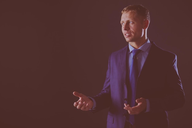 Portrait of successful businessman isolated on dark background