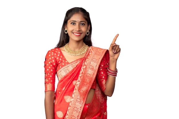 Portrait of a successful cheerful young girl pointing and presenting something with a hand or finger with a happy smiling face