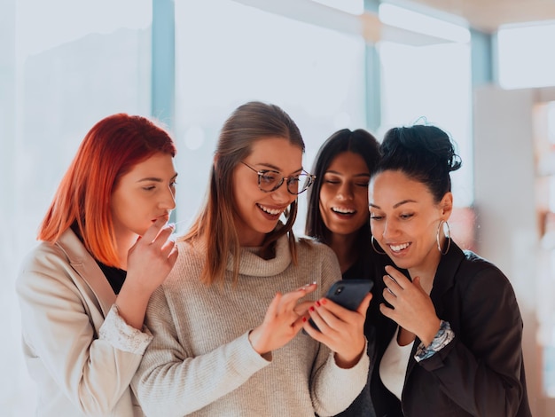 Portrait of successful group at modern office. Happy womans using smartphone