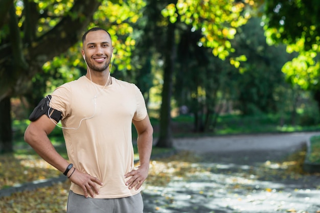 Portrait of successful man in park hispanic man with headphones listening to music and audiobooks