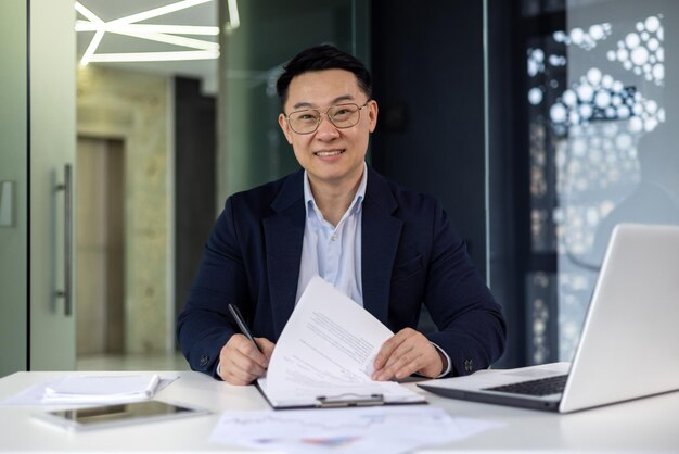 Portrait of successful mature adult boss asian businessman experienced smiling looking at camera man