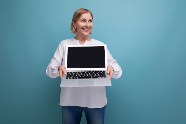 Portrait of successful mature business woman with blond hair with laptop with screen template