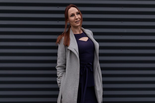 Portrait of a successful redhaired businessman on a background of a gray wall