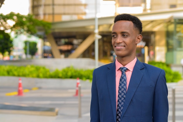 Portrait of successful young African businessman wearing suit and tie while thinking