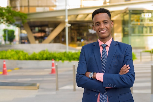 Portrait of successful young African businessman wearing suit and tie with arms crossed