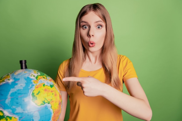 Portrait of surprised omg reaction lady direct forefinger globe continent wear sunglass yellow t-shirt