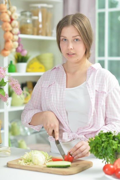 Portrait of teen girl preparing fresh salad