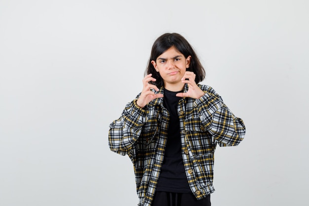 Portrait of teen girl pretending to hold something in casual shirt and looking upset front view