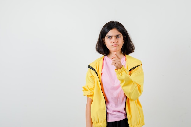 Portrait of teen girl warning with finger in t-shirt, jacket and looking angry front view