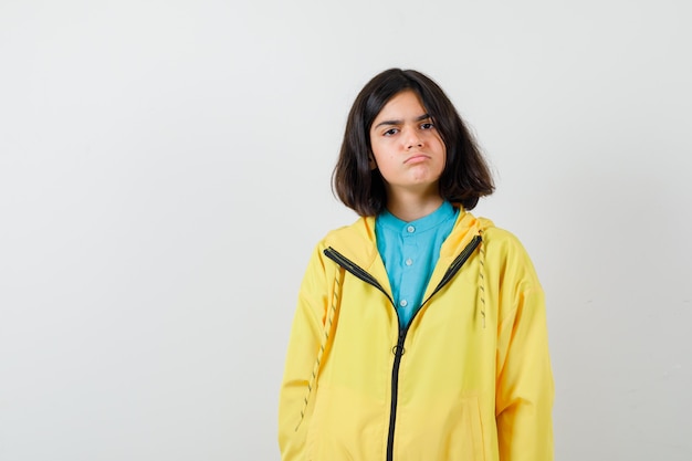 Portrait of teen girl in yellow jacket and looking gloomy front view