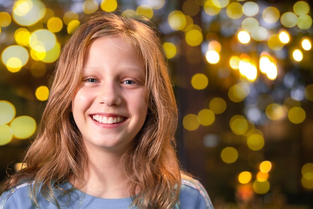 Portrait of the teenage girl against the background of the lights in the evening