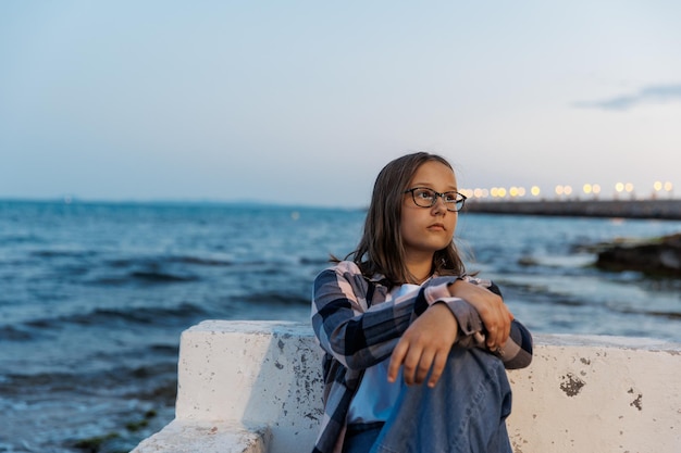 Portrait of a teenage girl by the sea on a summer evening