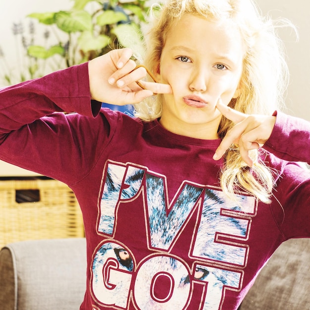 Photo portrait of teenage girl making face at home