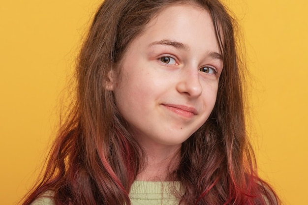 Portrait of a teenage girl on a yellow background The girl is in a positive mood