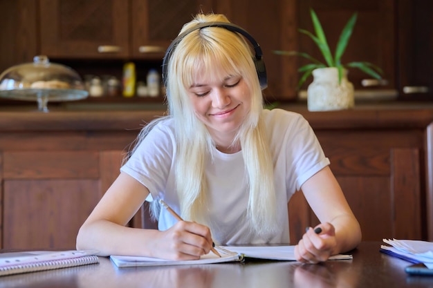 Portrait of a teenage student girl in headphones studying at home