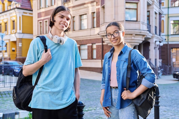 Portrait of teenage young guy and girl students looking at camera outdoor