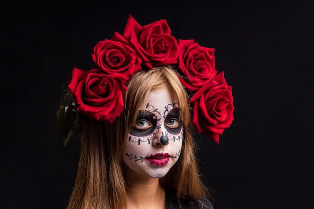 Portrait of teenager girl in a witch costume on studio background halloween make up