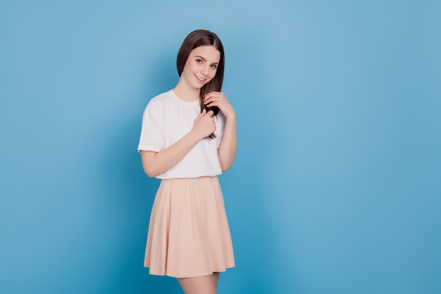 Portrait of tender adorable lovely romantic lady touch healthy hair on blue background