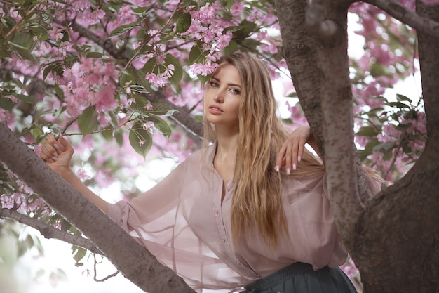 Portrait of the tender woman against the sakura flower