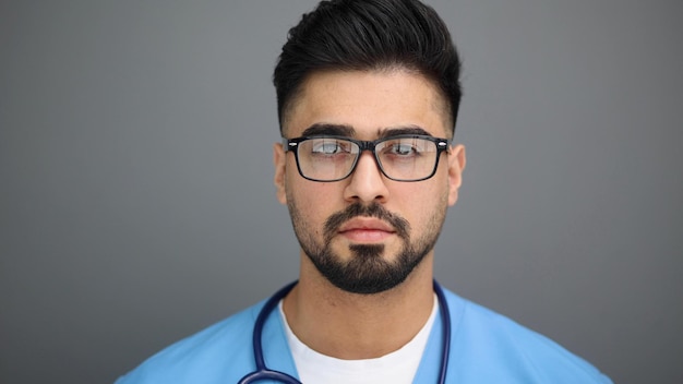 Portrait of a thoughtful male doctor on gray background