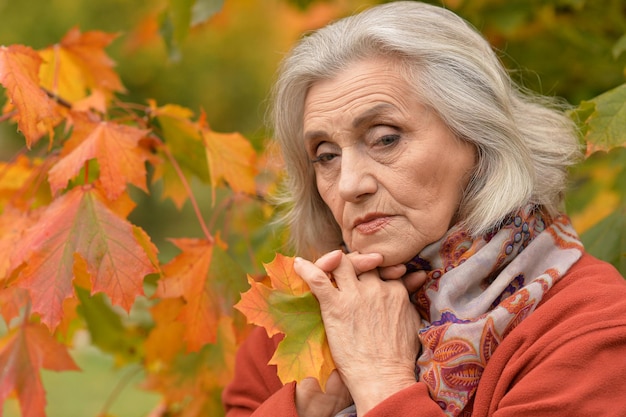 Portrait of thoughtful senior woman in autumn park